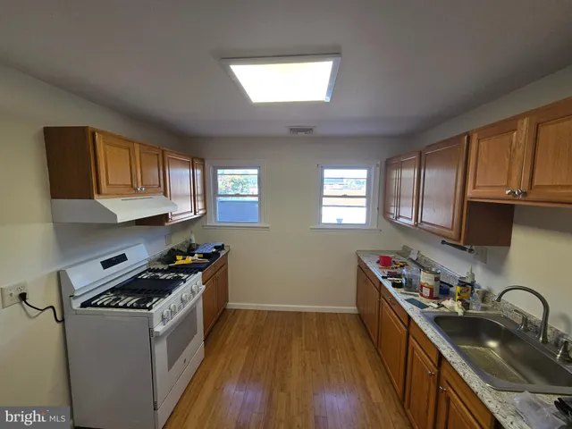 a kitchen with stainless steel appliances a sink stove and cabinets