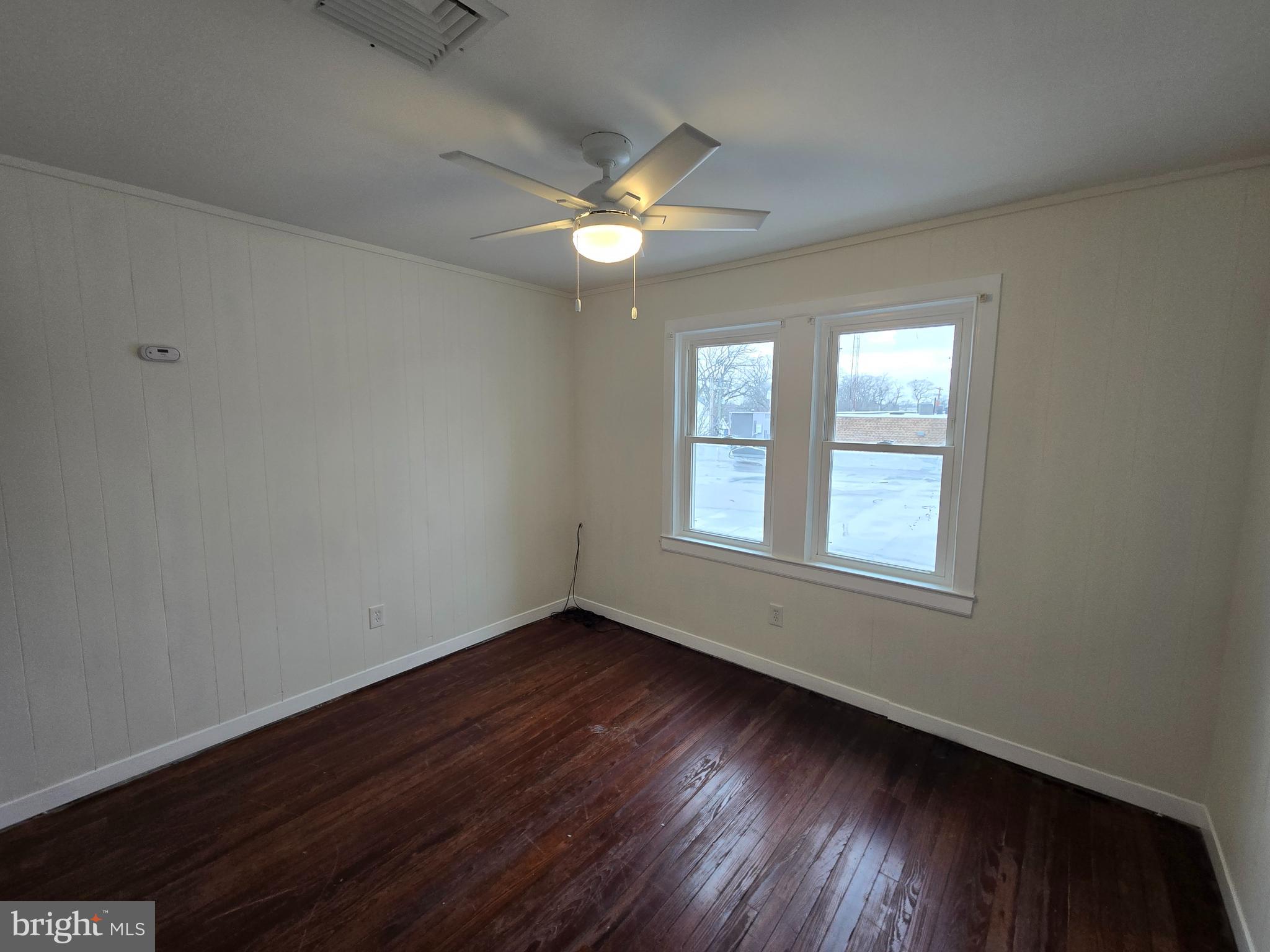 130 South Broadway Pitman, NJ 08071 - Photo 9 of 11 a view of an empty room with wooden floor and a window