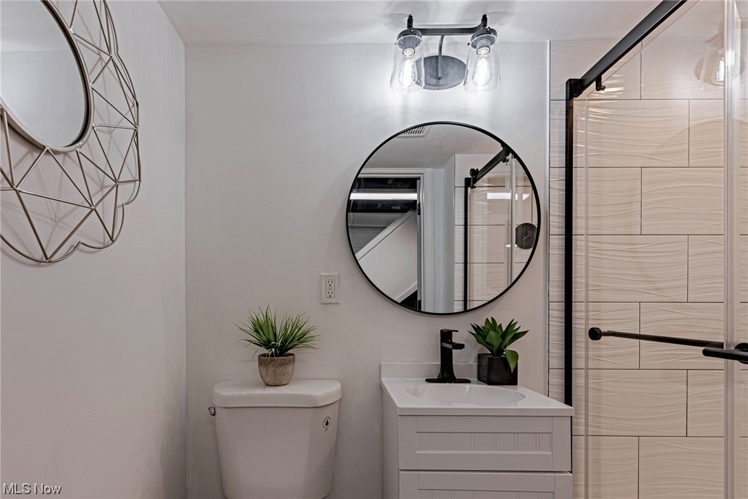 11815 Derby Road Garfield Heights, OH 44125 - Photo 24 of 31 Bathroom featuring vanity, mirror, and tiled shower