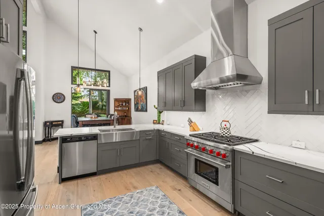 a kitchen with stainless steel appliances a sink a stove and a wooden floors