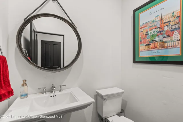 a bathroom with a sink mirror and toilet