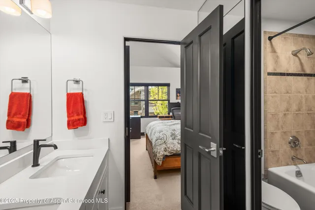 a bathroom with a tub sink and mirror