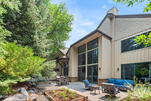 a view of backyard with outdoor seating and plants