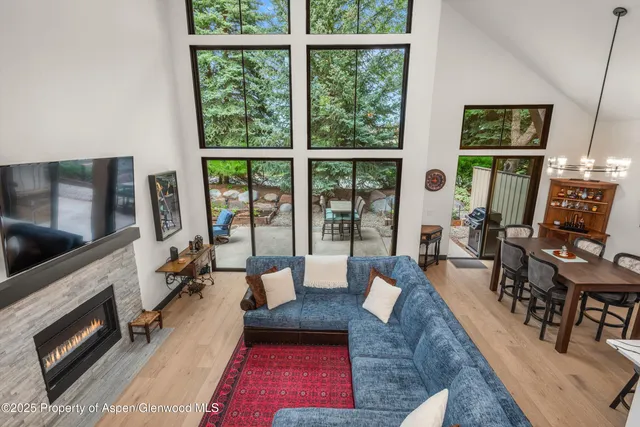 a living room with furniture large window and a fireplace