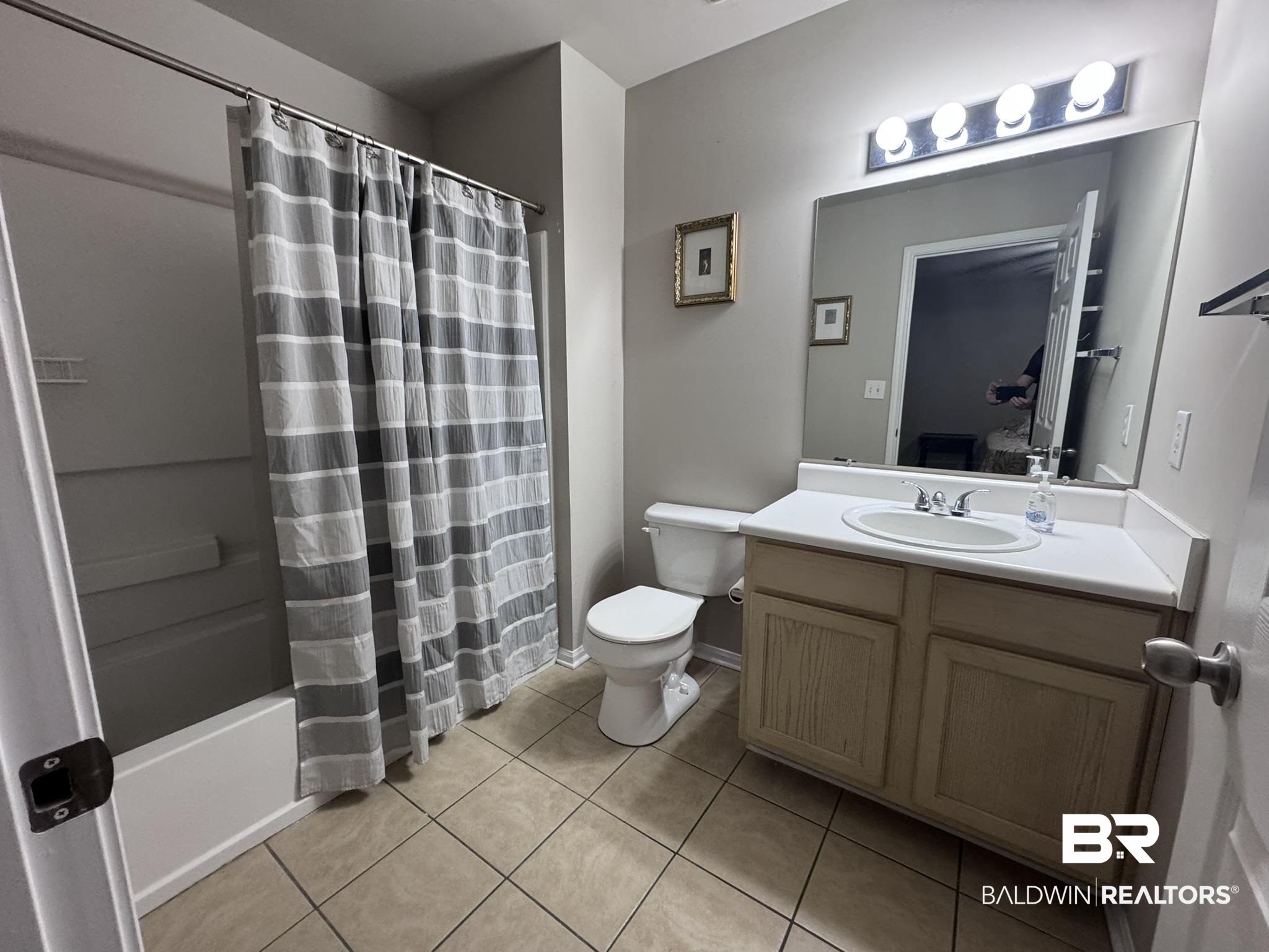 1517 Regency Road, Unit 131 Gulf Shores, AL 36542 - Photo 15 of 21 Bathroom with vanity, shower / bath combo with shower curtain, and light tile patterned floors