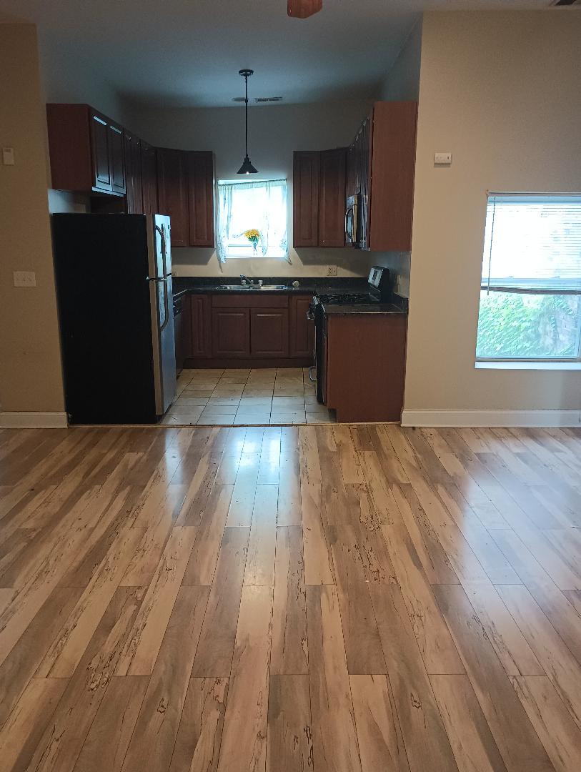 2236 West Monroe Street Chicago, IL 60612 - Photo 11 of 36 a kitchen with stainless steel appliances granite countertop a refrigerator a sink dishwasher a stove and white countertops with wooden floor