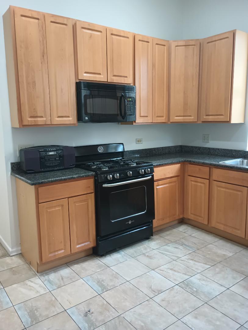 2236 West Monroe Street Chicago, IL 60612 - Photo 29 of 36 a kitchen with granite countertop white cabinets and stainless steel appliances