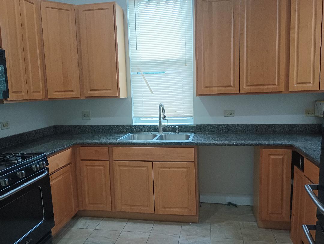 2236 West Monroe Street Chicago, IL 60612 - Photo 30 of 36 a kitchen with granite countertop white cabinets and stainless steel appliances