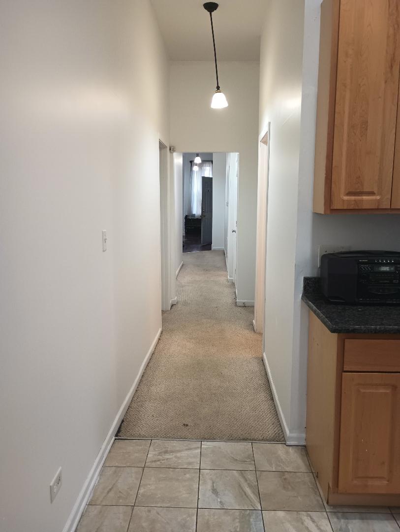 2236 West Monroe Street Chicago, IL 60612 - Photo 33 of 36 a view of a hallway to an empty room with wooden floor and cabinets
