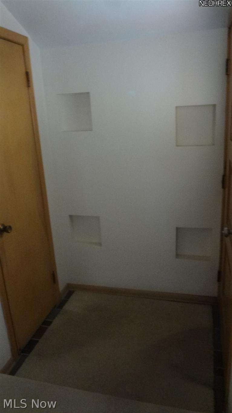 Entry with guest closet and built in display shelves