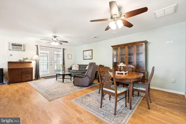 a living room with furniture a chandelier fan and a wooden floor