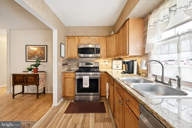 a kitchen with a sink a counter top space appliances and cabinets
