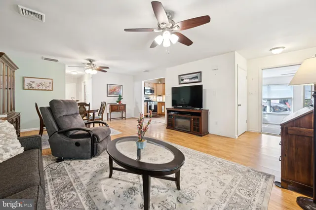 a living room with furniture a flat screen tv and kitchen view