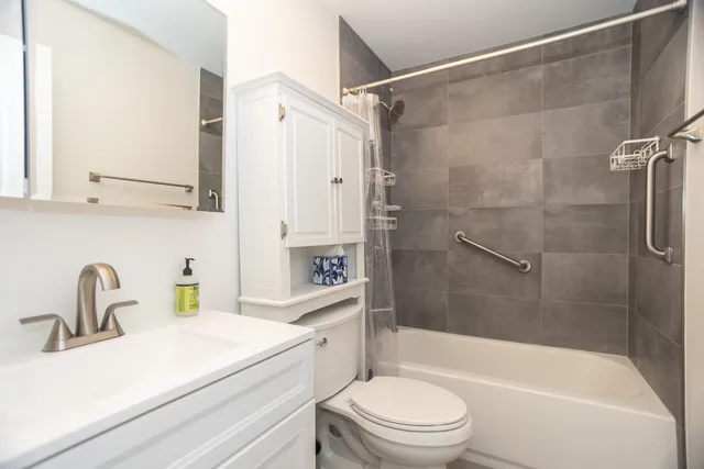 a bathroom with a sink a mirror toilet and bathtub