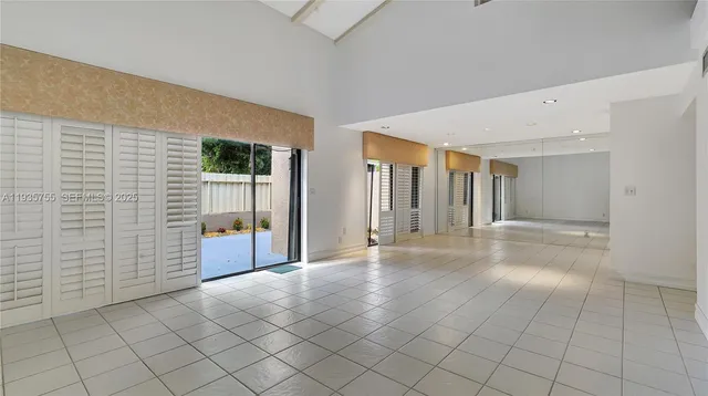 a view of a hallway with an empty room and kitchen