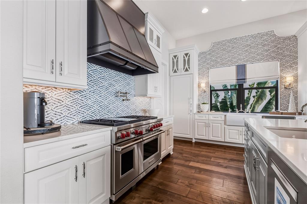 459 20th Avenue Indian Rocks Beach, FL 33785 - Photo 20 of 70 a kitchen with white cabinets and a stove top oven