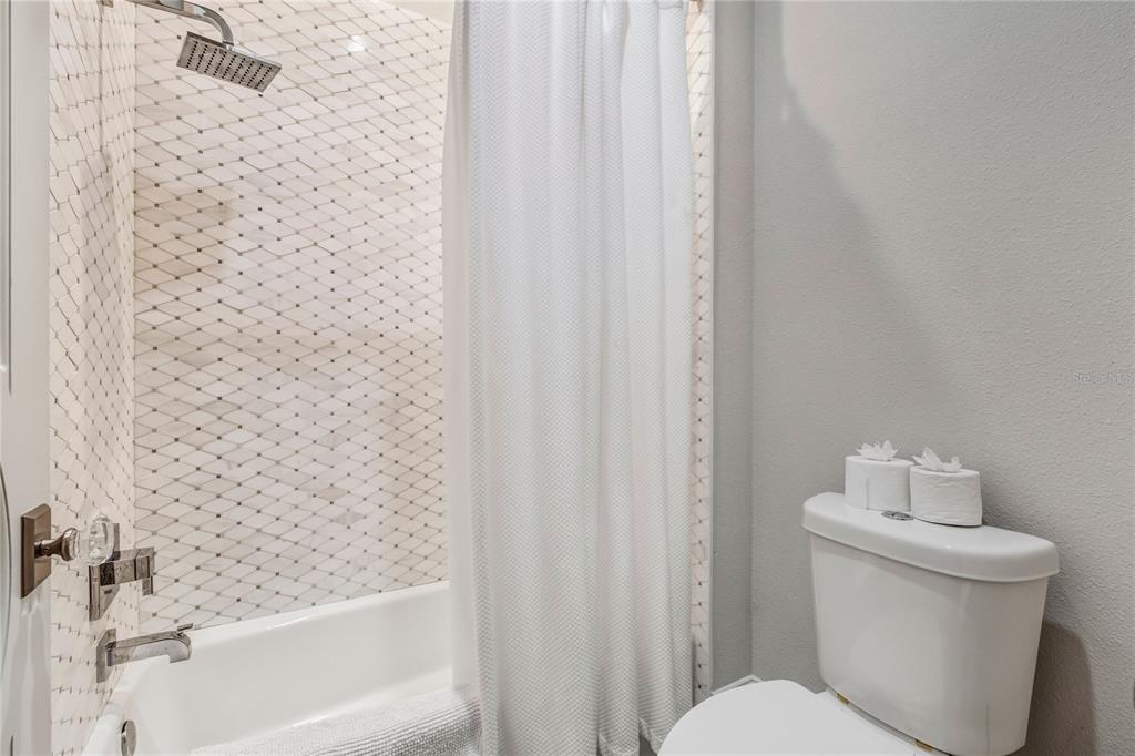 459 20th Avenue Indian Rocks Beach, FL 33785 - Photo 51 of 70 a white toilet sitting next to a shower curtain