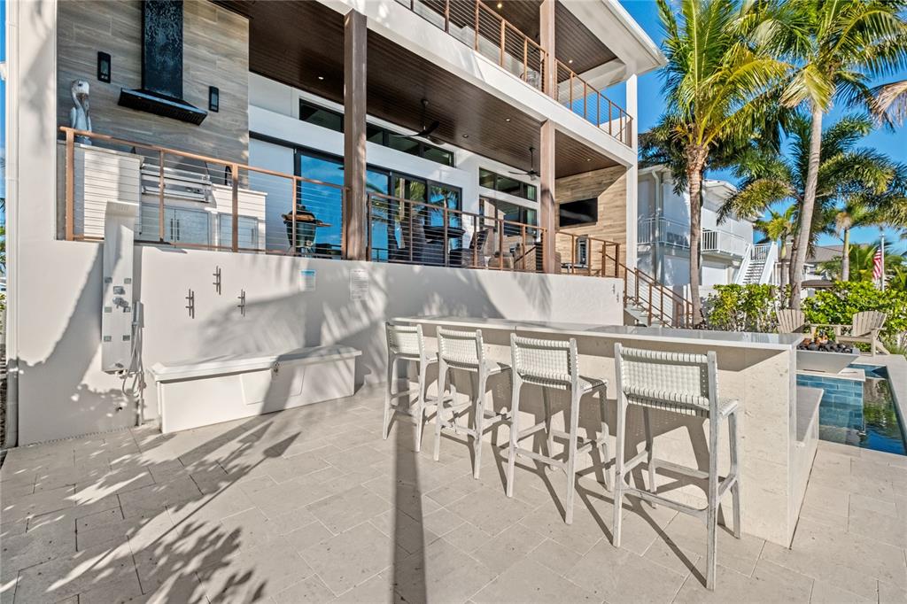 459 20th Avenue Indian Rocks Beach, FL 33785 - Photo 6 of 70 a view of a patio with a table and chairs and potted plants