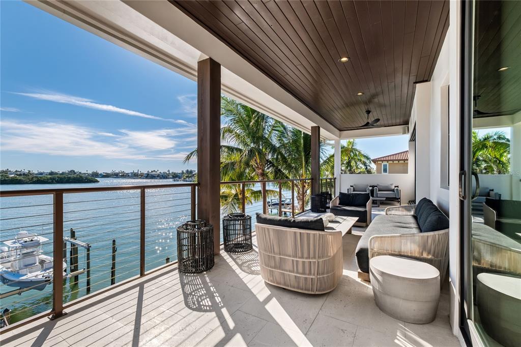 459 20th Avenue Indian Rocks Beach, FL 33785 - Photo 66 of 70 a view of a patio with couches chairs potted plants and floor to ceiling window