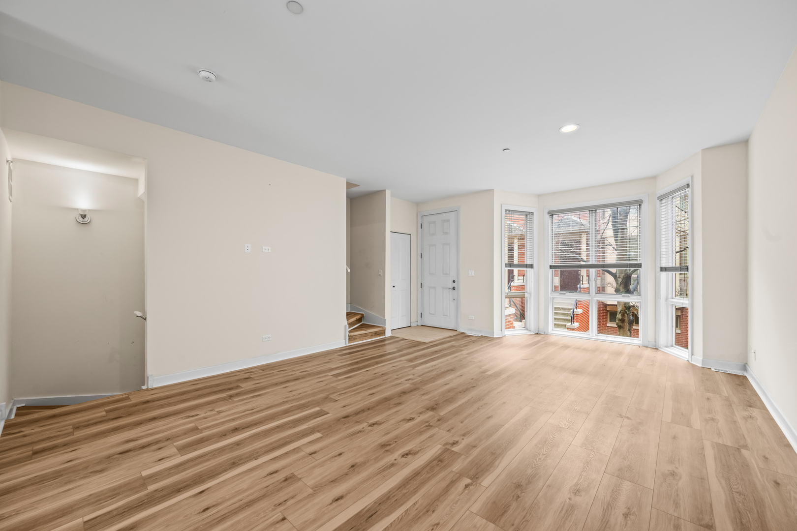 57 Northfield Terrace, Unit 57 Wheeling, IL 60090 - Photo 3 of 16 a view of an empty room with wooden floor and a window