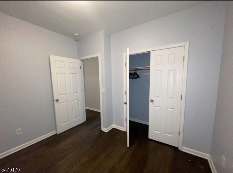 1519 Bower Street Linden, NJ 07036 - Photo 7 of 10 an empty room with wooden floor and white doors
