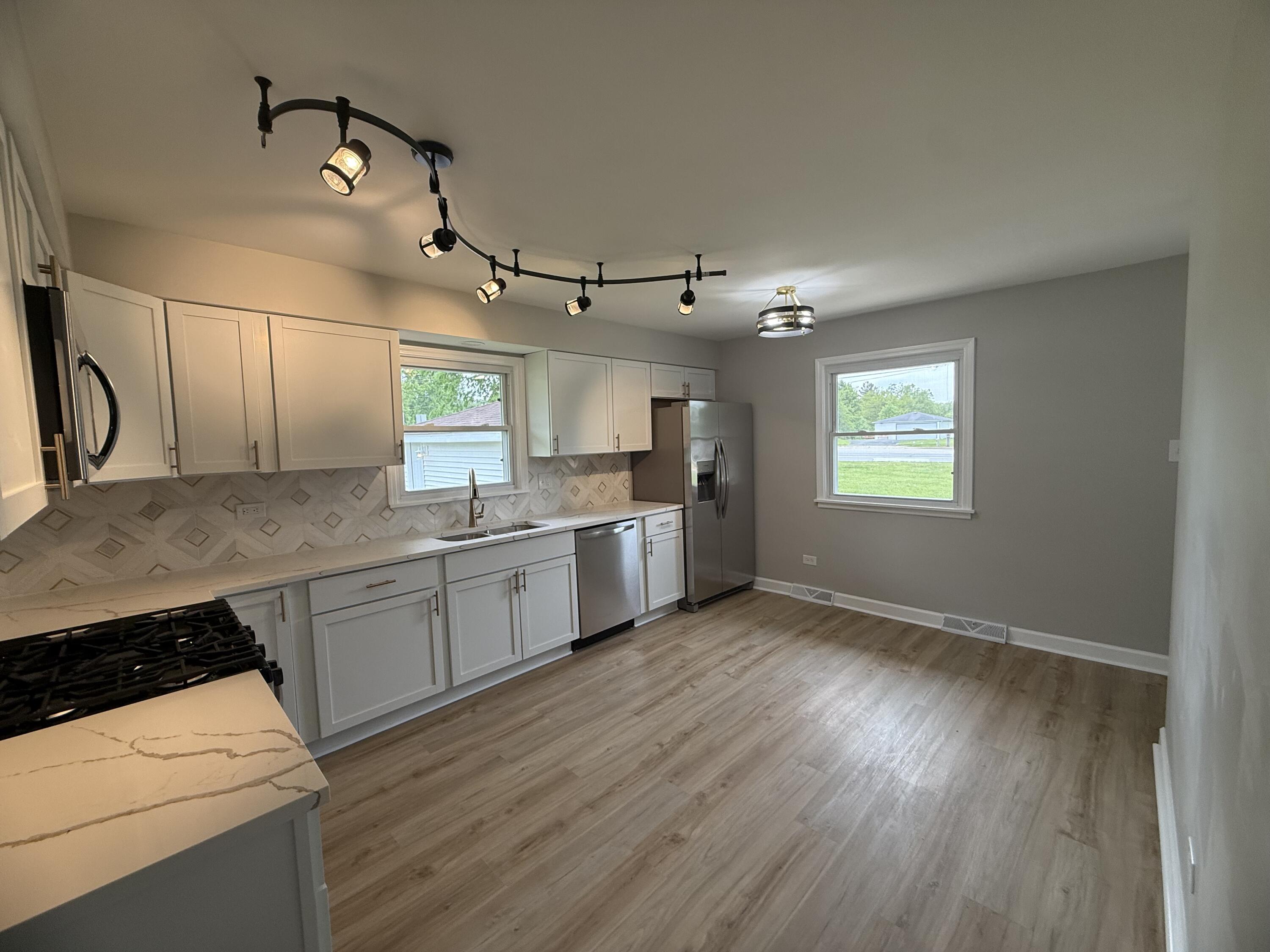 408 Cherry Hill Road Dyer, IN 46311 - Photo 9 of 31 a kitchen with granite countertop a sink cabinets and wooden floor