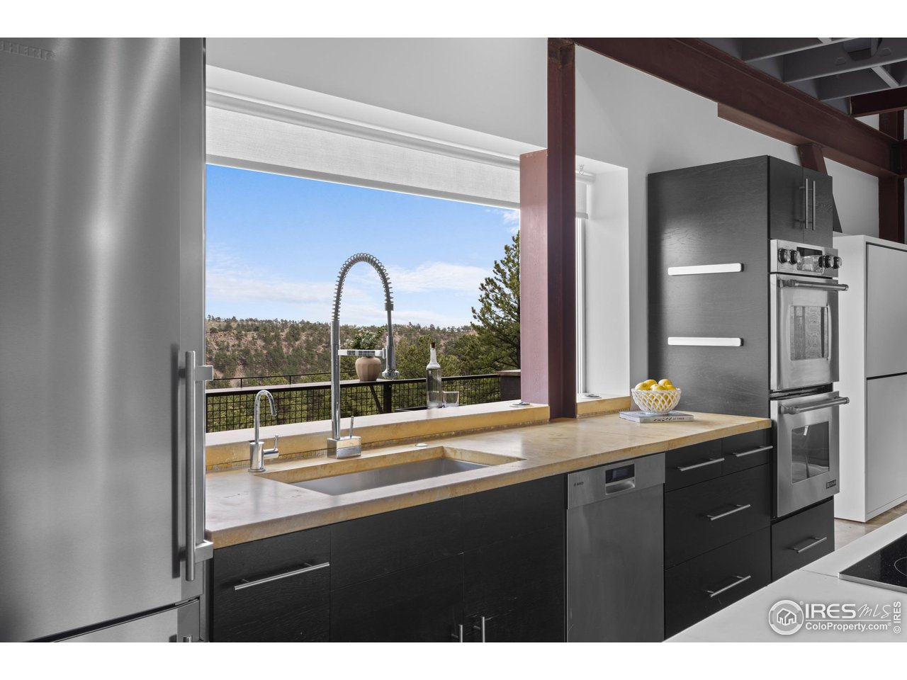 1440 Reed Ranch Road Boulder, CO 80302 - Photo 17 of 40 The windows in the sleek and modern kitchen open completely to let the outside in and create an easy pass through to the bar for entertaining.