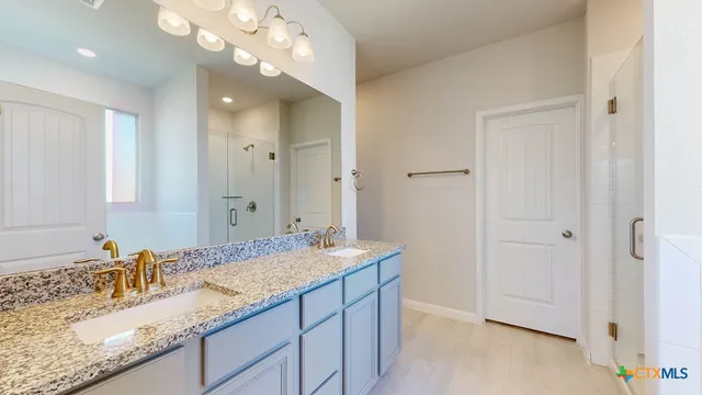 a bathroom with a sink a light fixture and a mirror