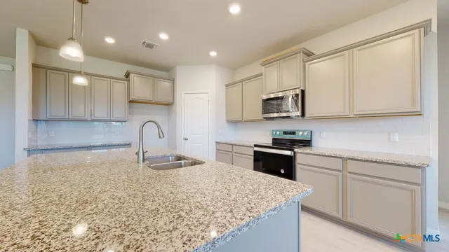 a kitchen with stainless steel appliances granite countertop a sink stove and cabinets