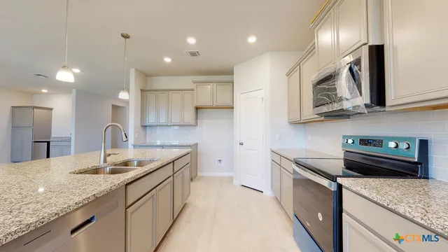 a kitchen with sink stove and cabinets