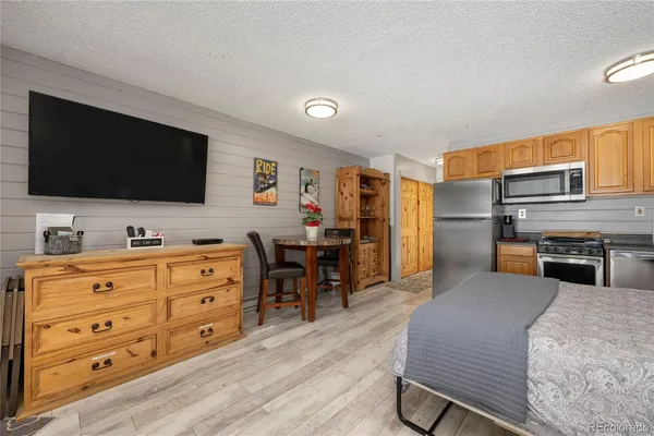 a room with furniture flat screen tv and refrigerator