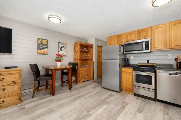 a kitchen with stainless steel appliances kitchen island granite countertop a refrigerator and a stove top oven