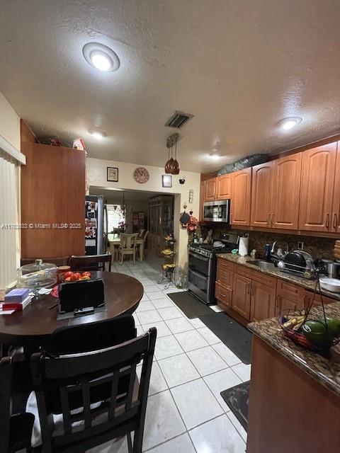 261 East 37th Street Hialeah, FL 33013 - Photo 5 of 13 a kitchen with a stove a sink a refrigerator and chairs