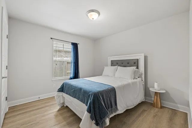 a bedroom with a large bed and a chandelier