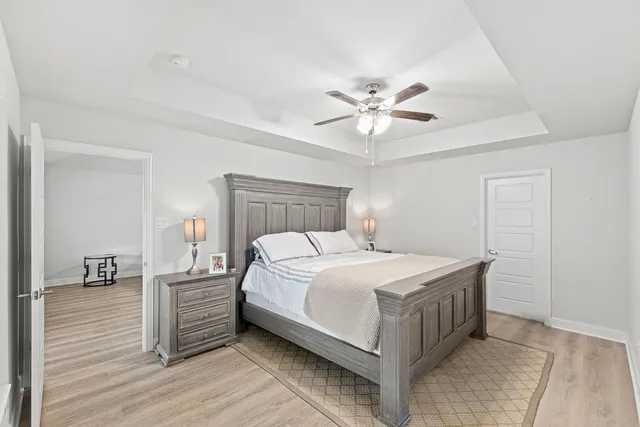 a bedroom with a bed a chandelier and a window