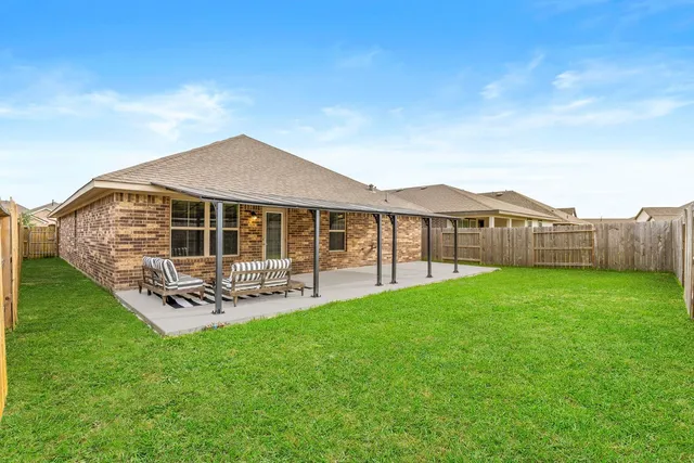 a view of a house with a yard and sitting area