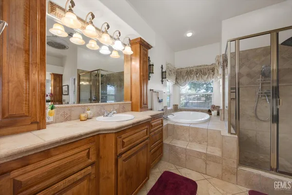 a kitchen with stainless steel appliances granite countertop a stove top oven a refrigerator a sink with white cabinets and wooden floor