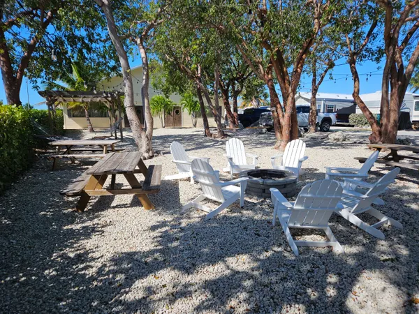 a view of a backyard with table and chairs and a fire pit