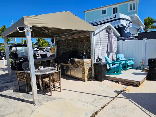 a view of a patio with table and chairs a barbeque