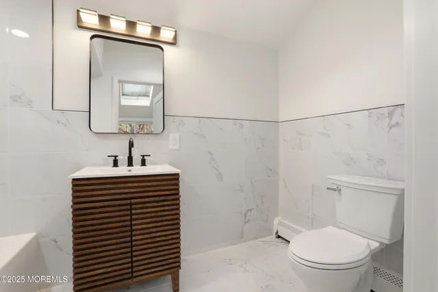 a bathroom with a sink a toilet and mirror