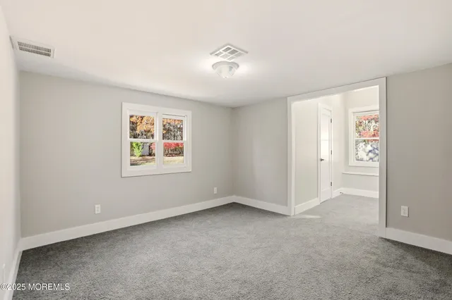 an empty room with windows and closet