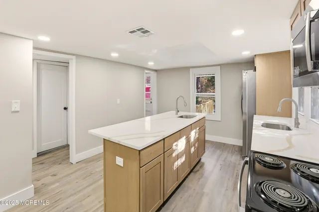 a kitchen with stainless steel appliances granite countertop a sink a stove and a refrigerator