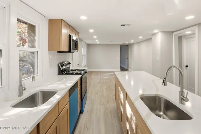 a kitchen with stainless steel appliances granite countertop a sink stove and refrigerator