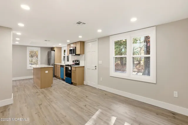 a kitchen with stainless steel appliances granite countertop a stove a sink and a refrigerator