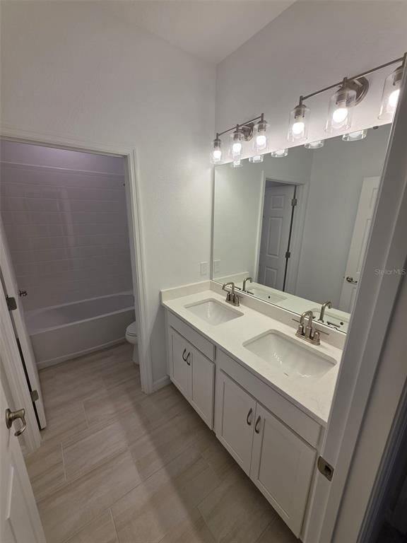 6008 Vision Road St. Cloud, FL 34771 - Photo 11 of 33 a bathroom with a double vanity sink and a mirror