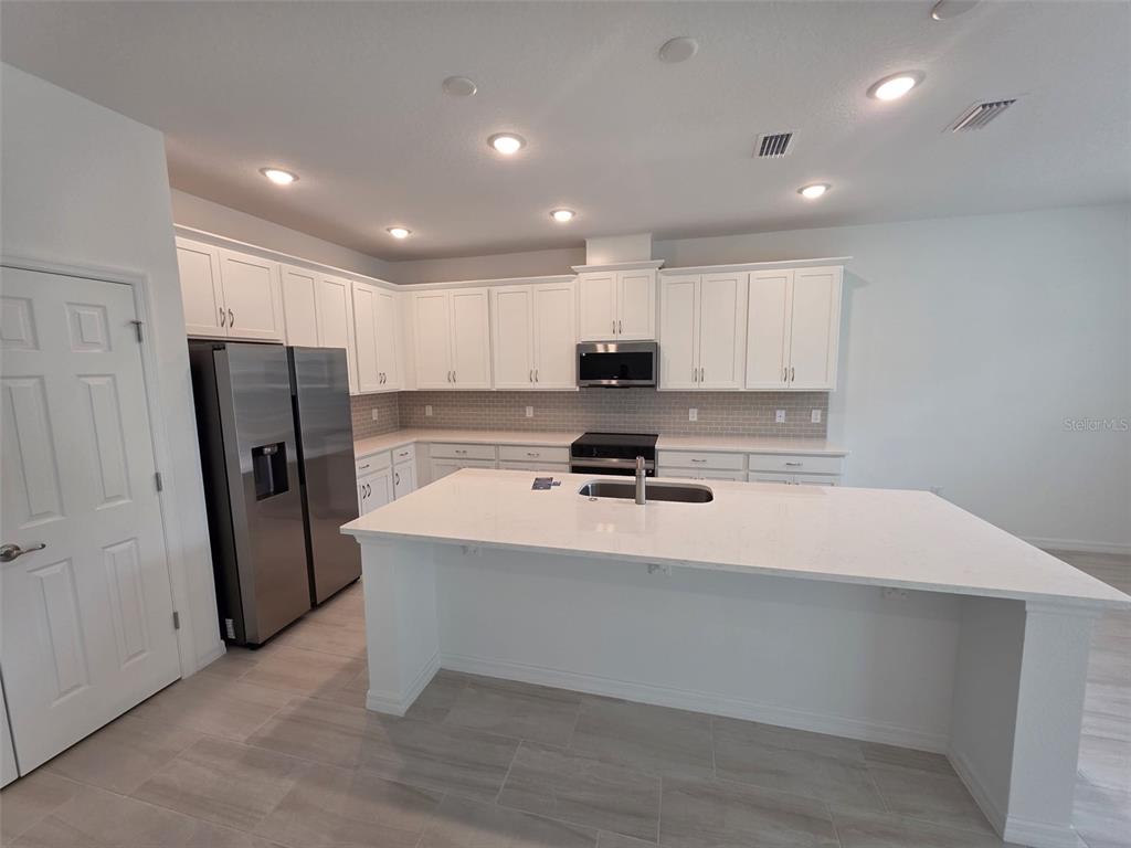 6008 Vision Road St. Cloud, FL 34771 - Photo 19 of 33 a kitchen with refrigerator and window