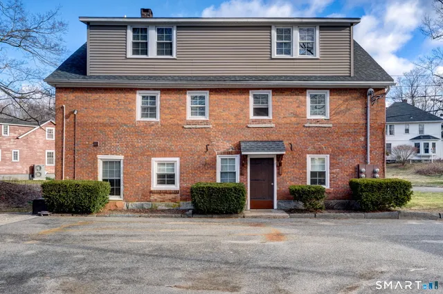 a front view of a house with a yard and plants