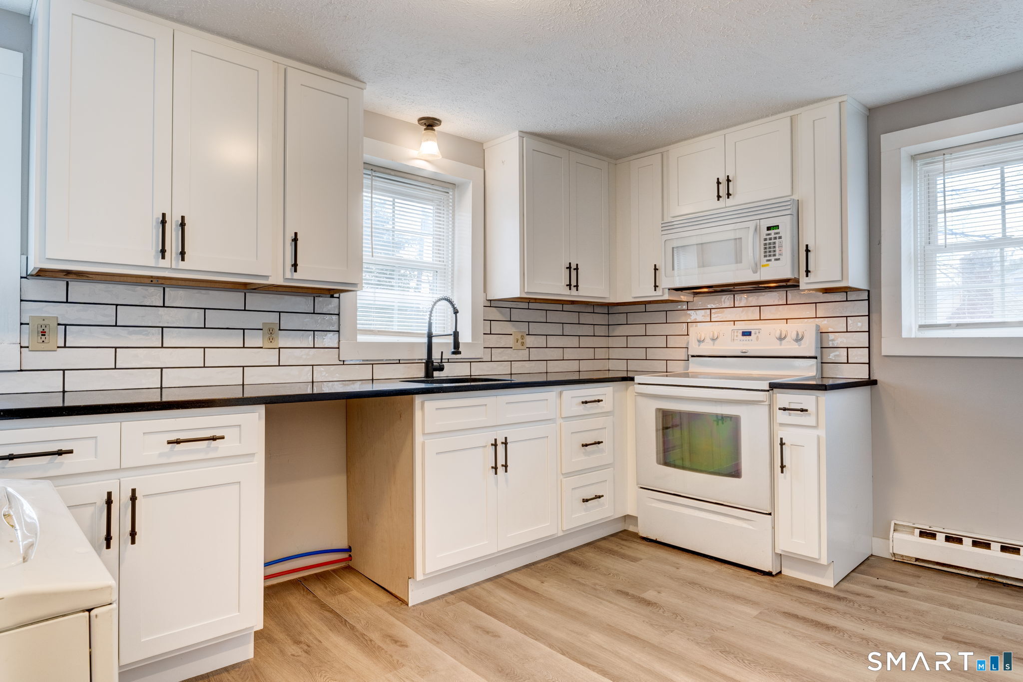 8 Maple Avenue Plymouth, CT 06782 - Photo 3 of 20 a kitchen with white cabinets and white appliances