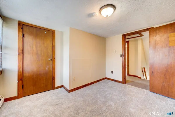 an empty room with closet and a chandelier fan