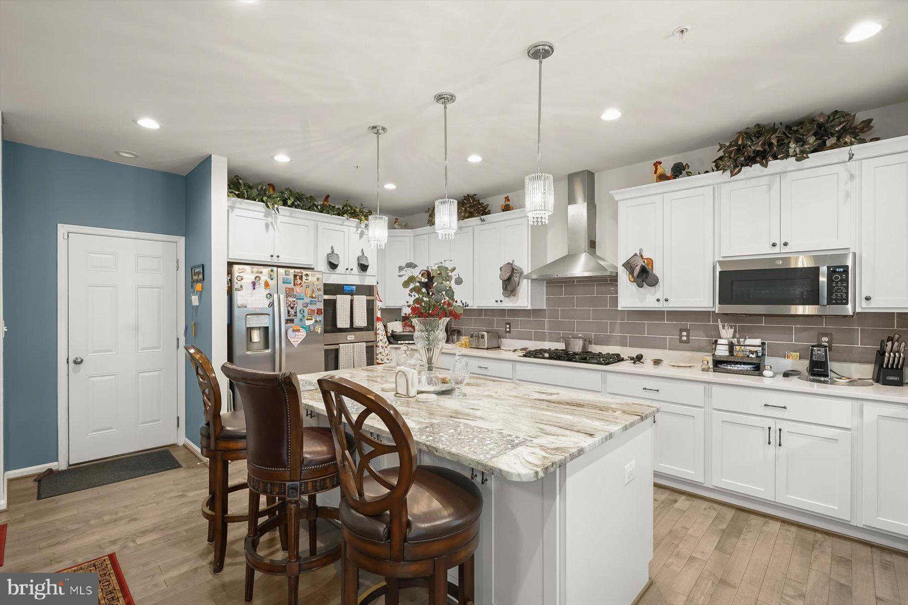 2102 St James Road Accokeek, MD 20607 - Photo 14 of 43 a kitchen with stainless steel appliances kitchen island granite countertop a table chairs sink and cabinets